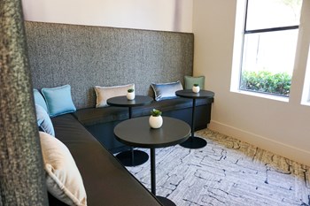 Sorelle apartments resident lounge with blue benches and a round black table